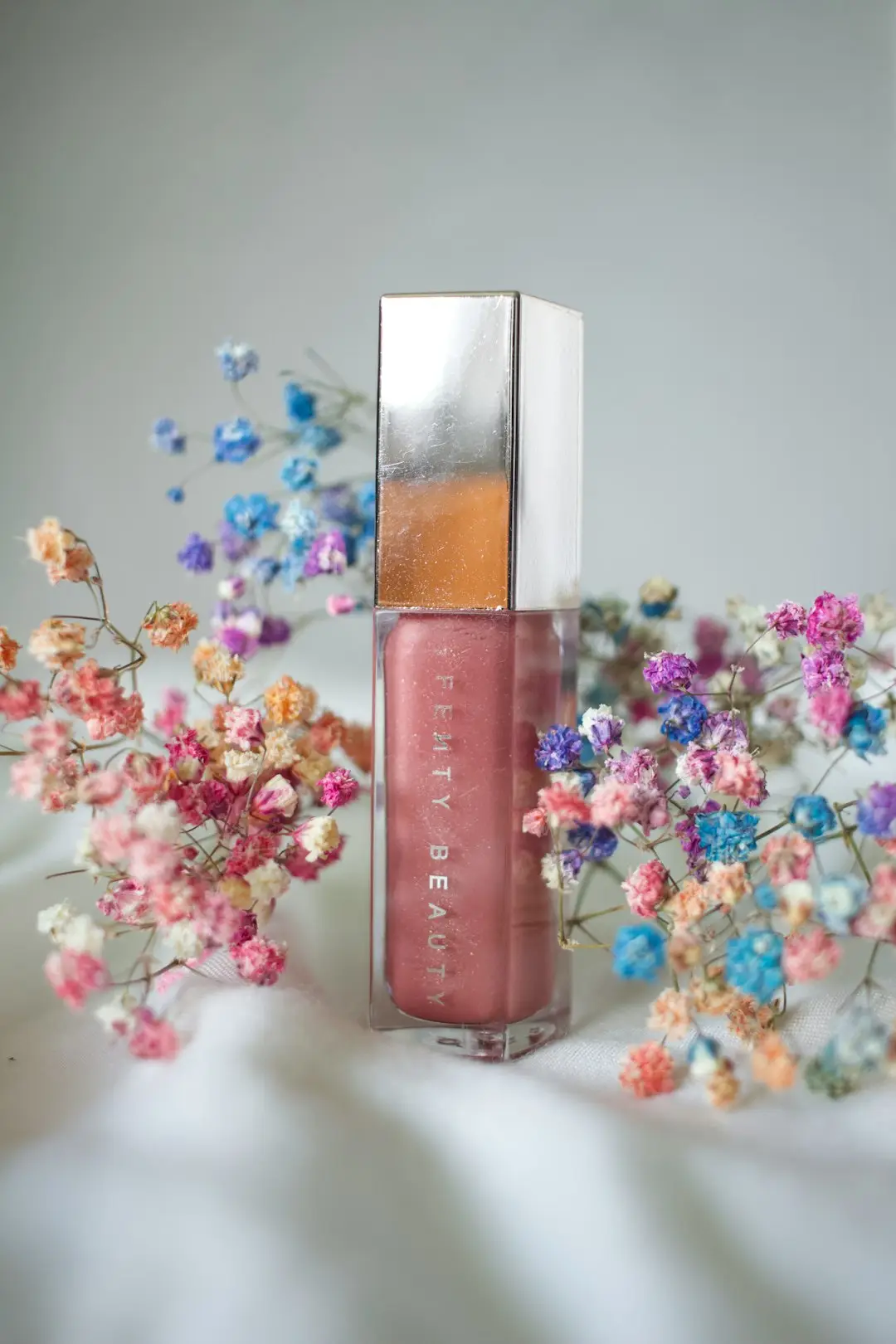 Gloss labial sobre bancada clara, luz natural suave
