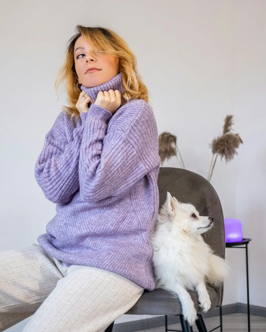 Mulher de tricô de gola alta cor neutra, ombros relaxados, luz suave de manhã de inverno