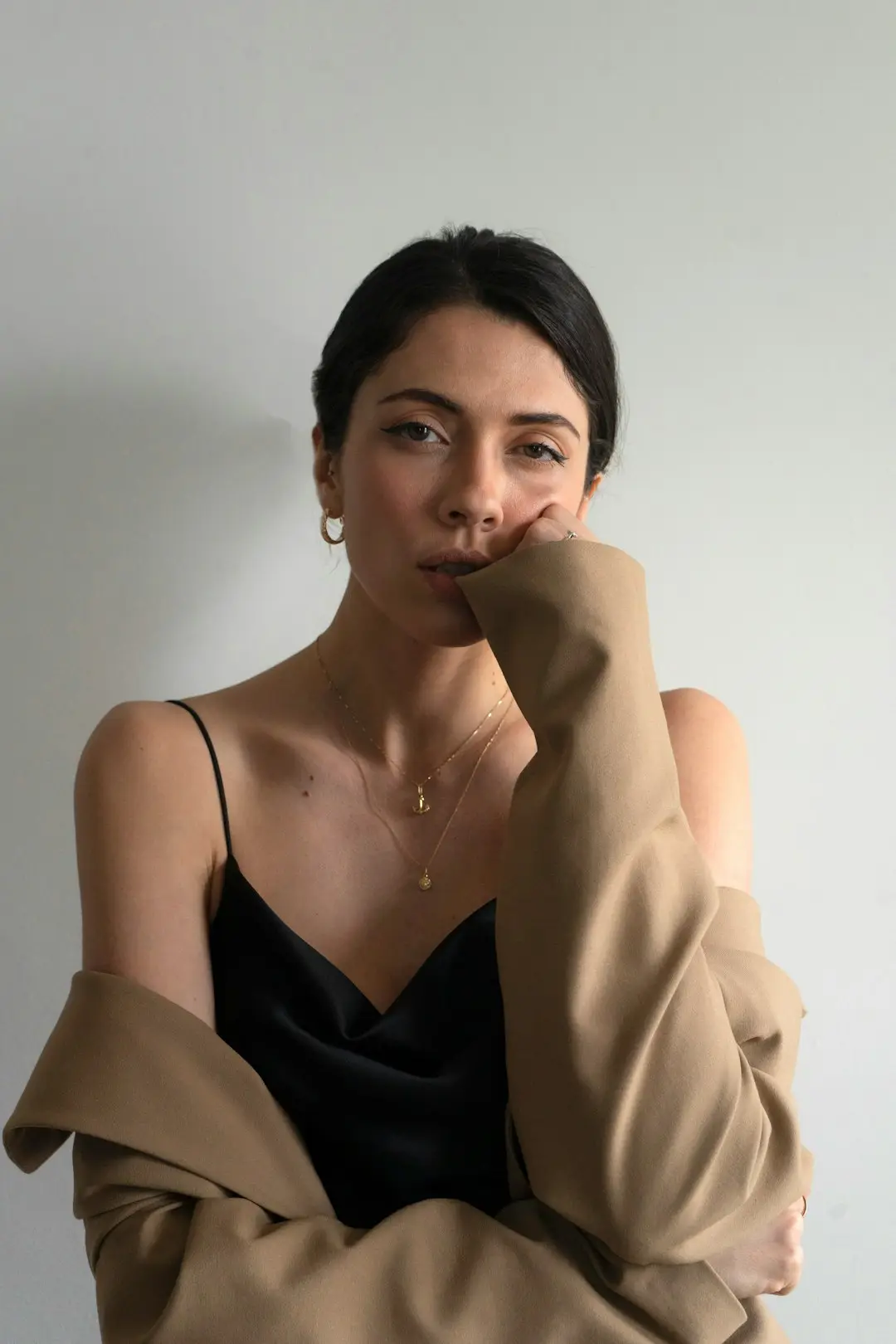 Conjunto em tons de areia, blusa e calça no mesmo bege em duas profundidades, sob luz suave de manhã